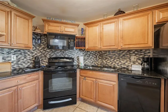 a kitchen with granite countertop a sink stove and cabinets