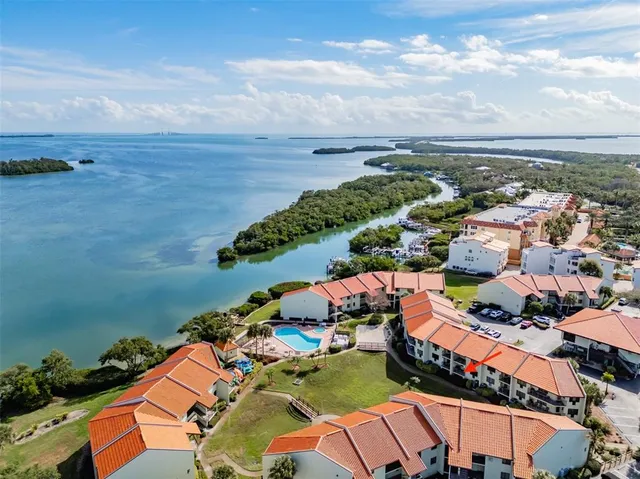 an aerial view of a city with lots of residential buildings ocean and mountain view in back