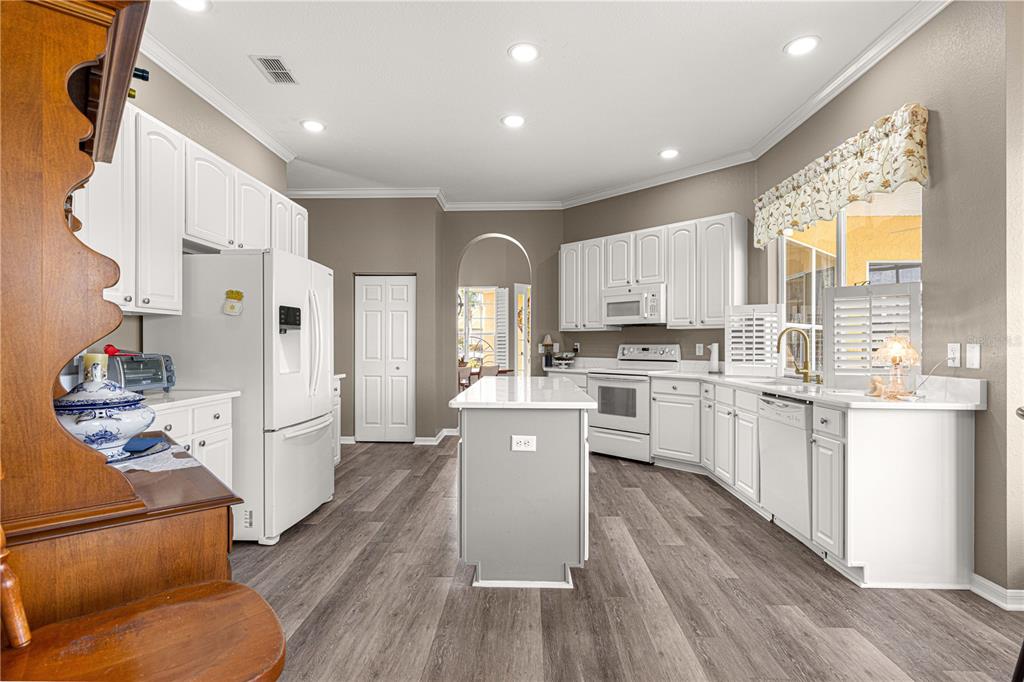 11799 Southeast 173rd Ln Road Summerfield, FL 34491 - Photo 12 of 83 a kitchen with white cabinets and stainless steel appliances