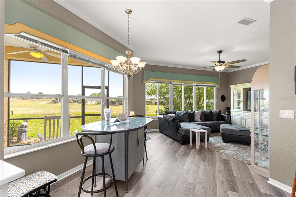 11799 Southeast 173rd Ln Road Summerfield, FL 34491 - Photo 18 of 83 a view of a dining room with furniture large windows and wooden floor