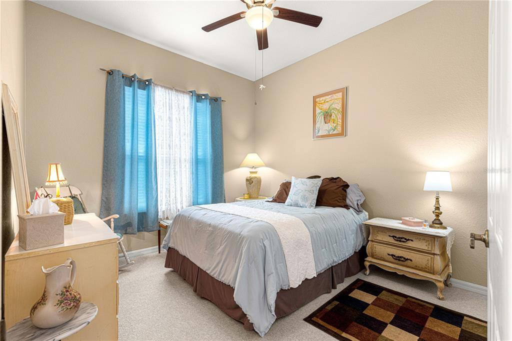 11799 Southeast 173rd Ln Road Summerfield, FL 34491 - Photo 31 of 83 a bedroom with a bed and a chandelier