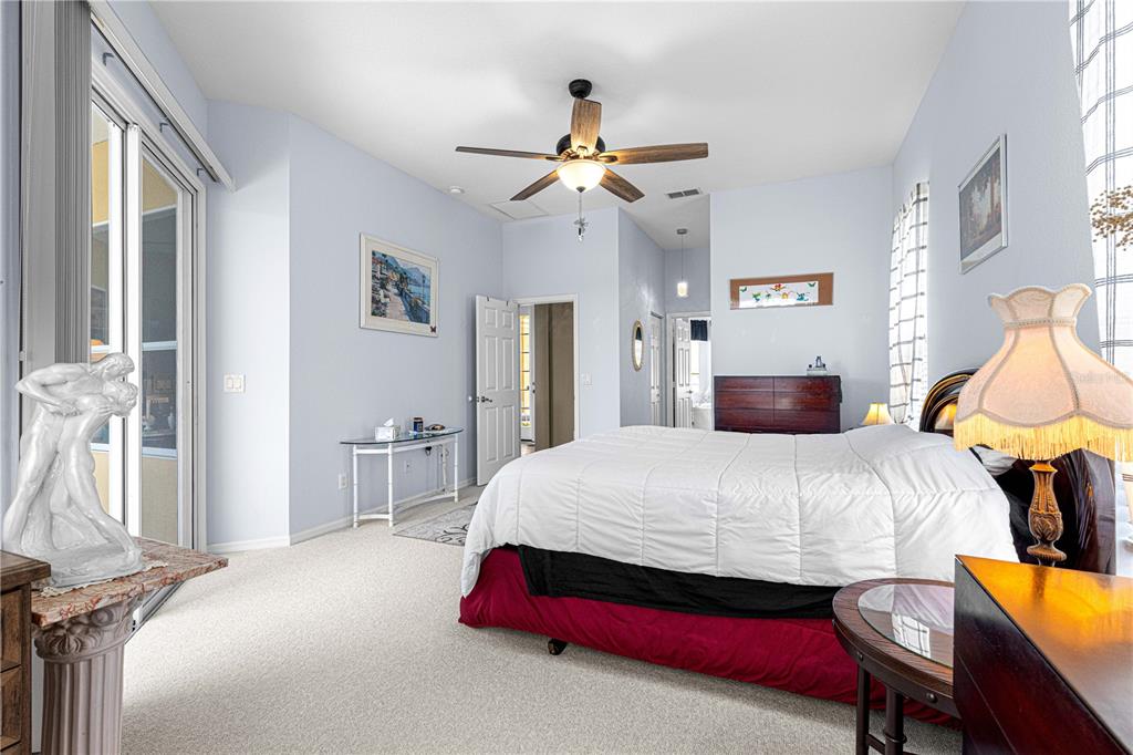 11799 Southeast 173rd Ln Road Summerfield, FL 34491 - Photo 35 of 83 a bedroom with a bed and a chandelier