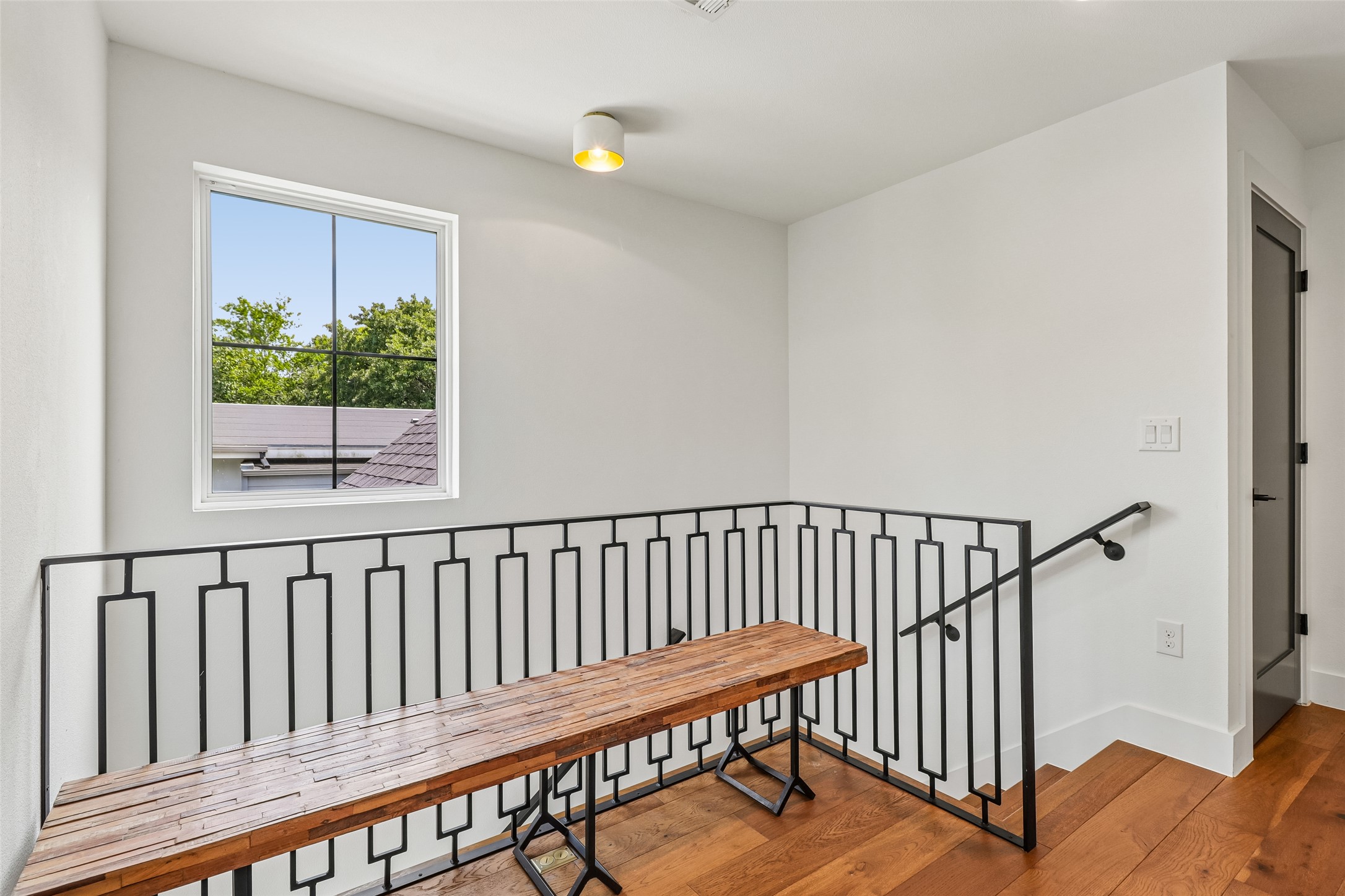 1706 Perez Street, Unit 1 Austin, TX 78721 - Photo 20 of 36 An inviting upper-level landing features polished hardwood floors and a sleek wrought-iron railing.