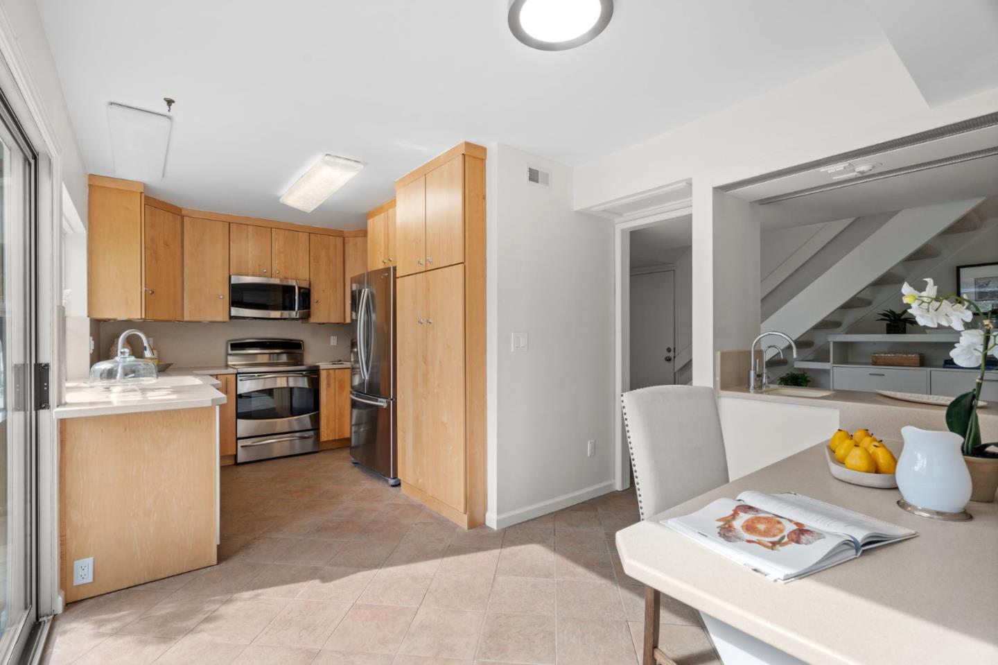 1032 Strayer Drive San Jose, CA 95129 - Photo 12 of 31 a kitchen with stainless steel appliances granite countertop a refrigerator a stove top oven a sink dishwasher and white cabinets with wooden floor