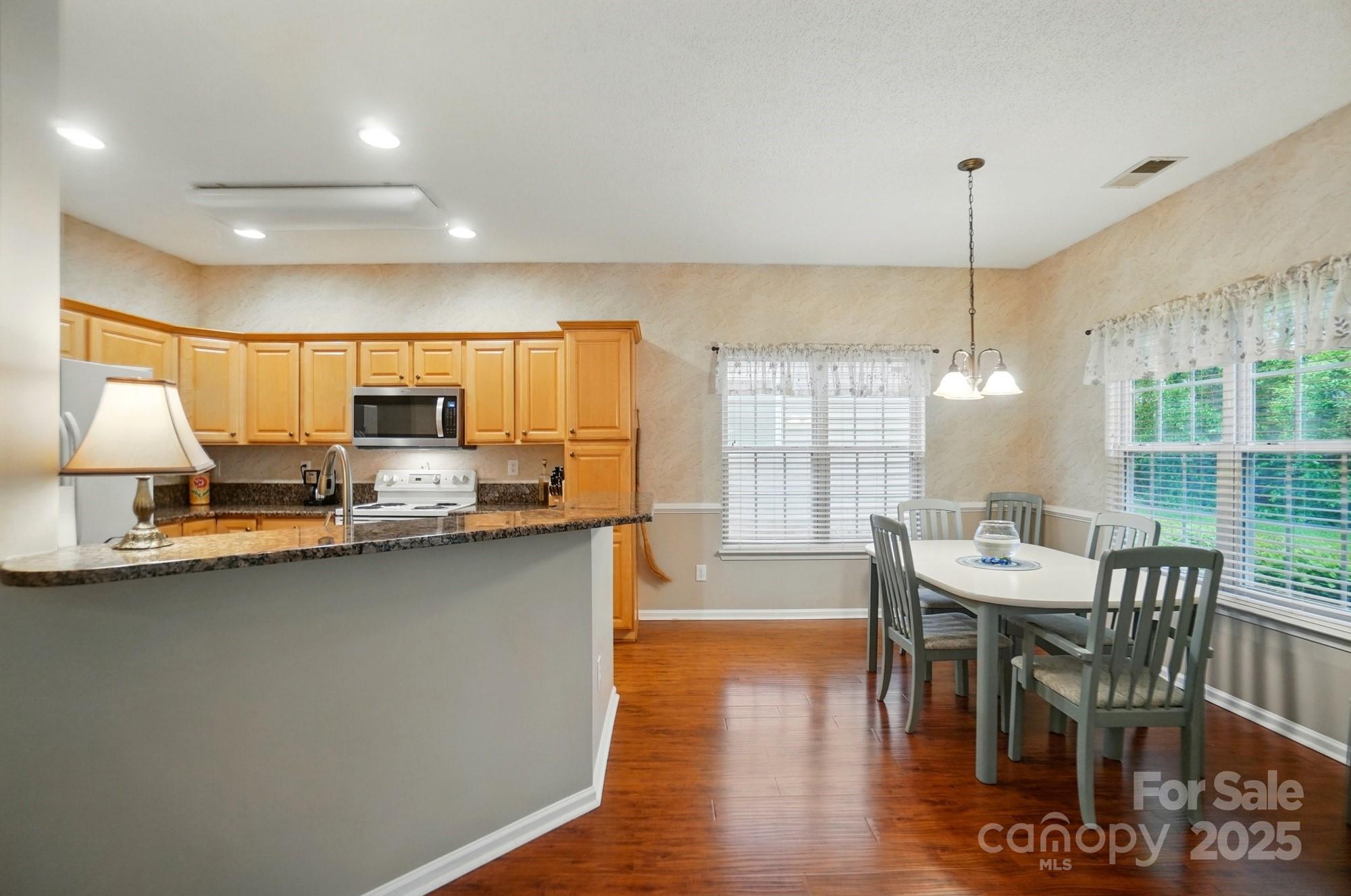 13505 Michael Lynn Road Charlotte, NC 28278 - Photo 8 of 24 a dining room with stainless steel appliances kitchen island granite countertop a table chairs and a wooden floor
