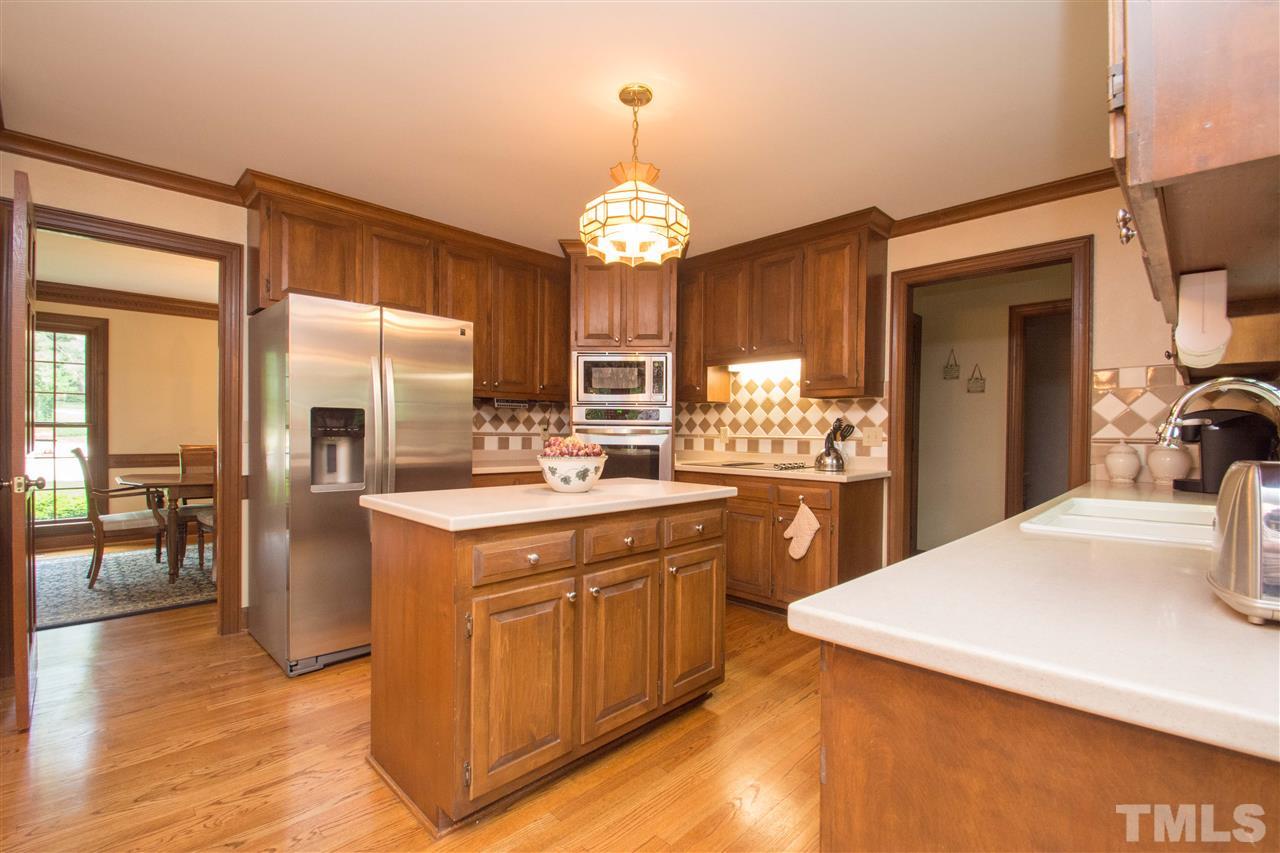 8000 Running Cedar Trail Raleigh, NC 27615 - Photo 7 of 18 a kitchen with stainless steel appliances granite countertop a stove a refrigerator a oven with a dining table and chairs