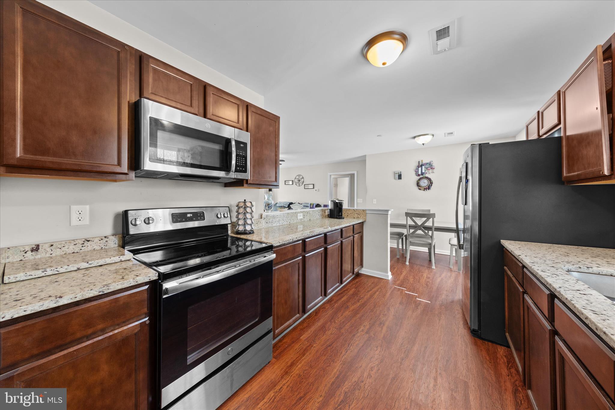 a kitchen with stainless steel appliances kitchen island granite countertop a stove a sink and a microwave