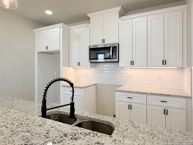 a kitchen with stainless steel appliances granite countertop a stove a sink and a microwave