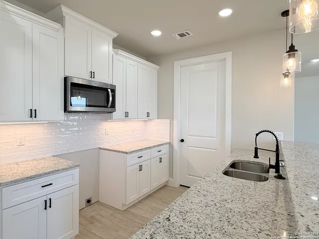 a kitchen with granite countertop a sink and a stove