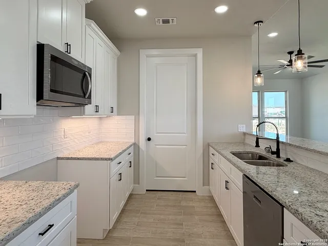 a kitchen with stainless steel appliances granite countertop a sink and a microwave