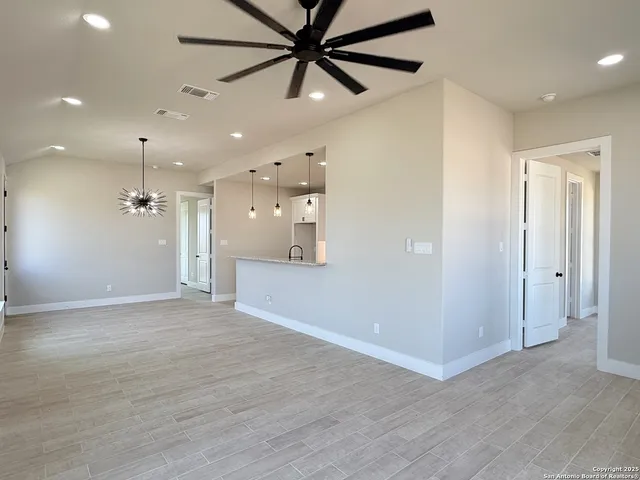 wooden floor in an empty room with a fan