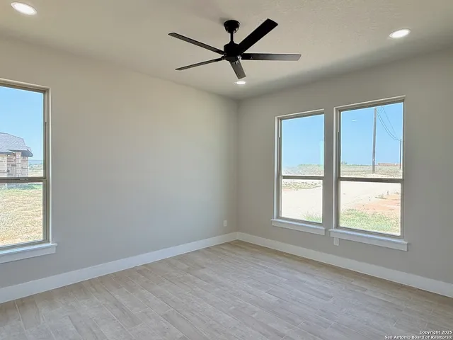 an empty room with a window and a ceiling fan