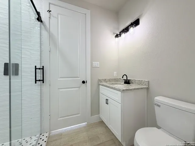 a bathroom with a granite countertop sink toilet and shower