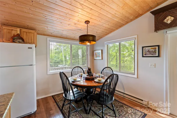 a kitchen with a dining table chairs and refrigerator