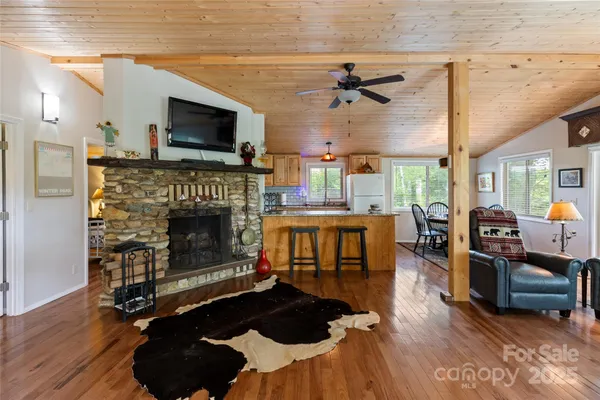 a living room with furniture a ceiling fan and a large window
