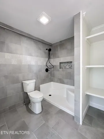 a bathroom with a toilet and a shower