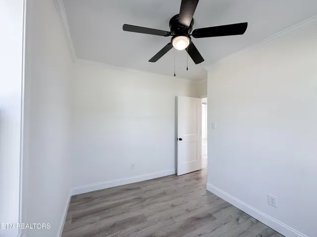 a view of room with wooden floor fan and window