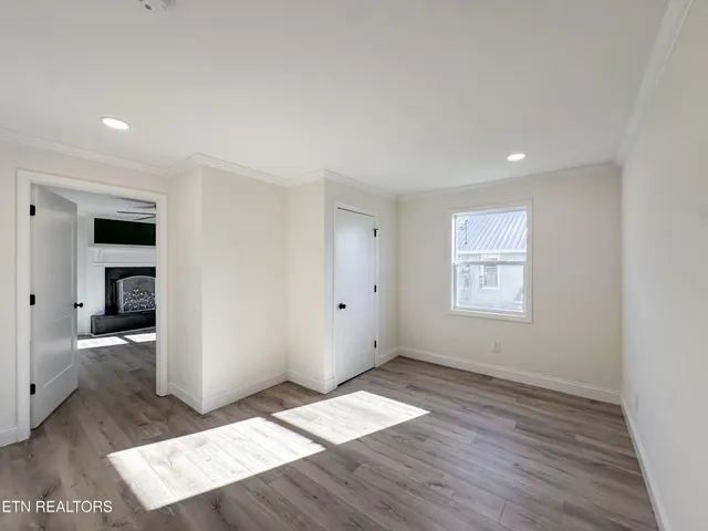 an empty room with wooden floor and windows