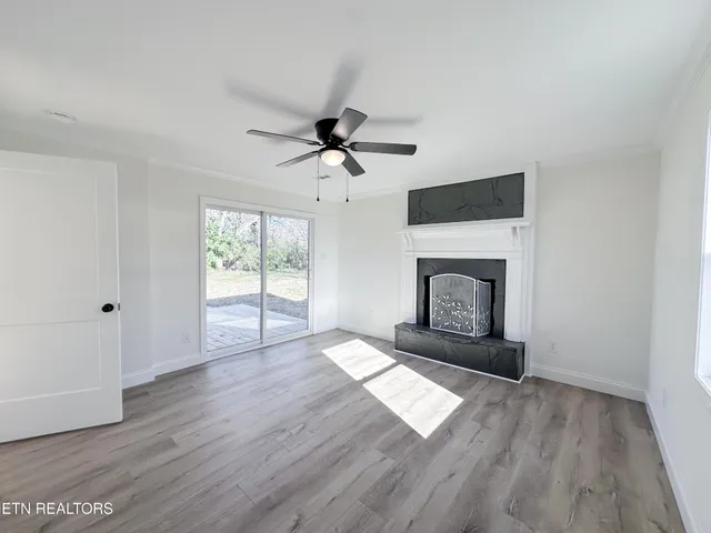 wooden floor fireplace and windows in an empty room
