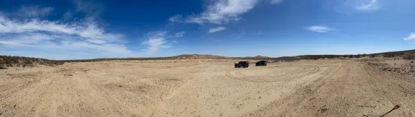 a view of a dry yard with mountains in the background