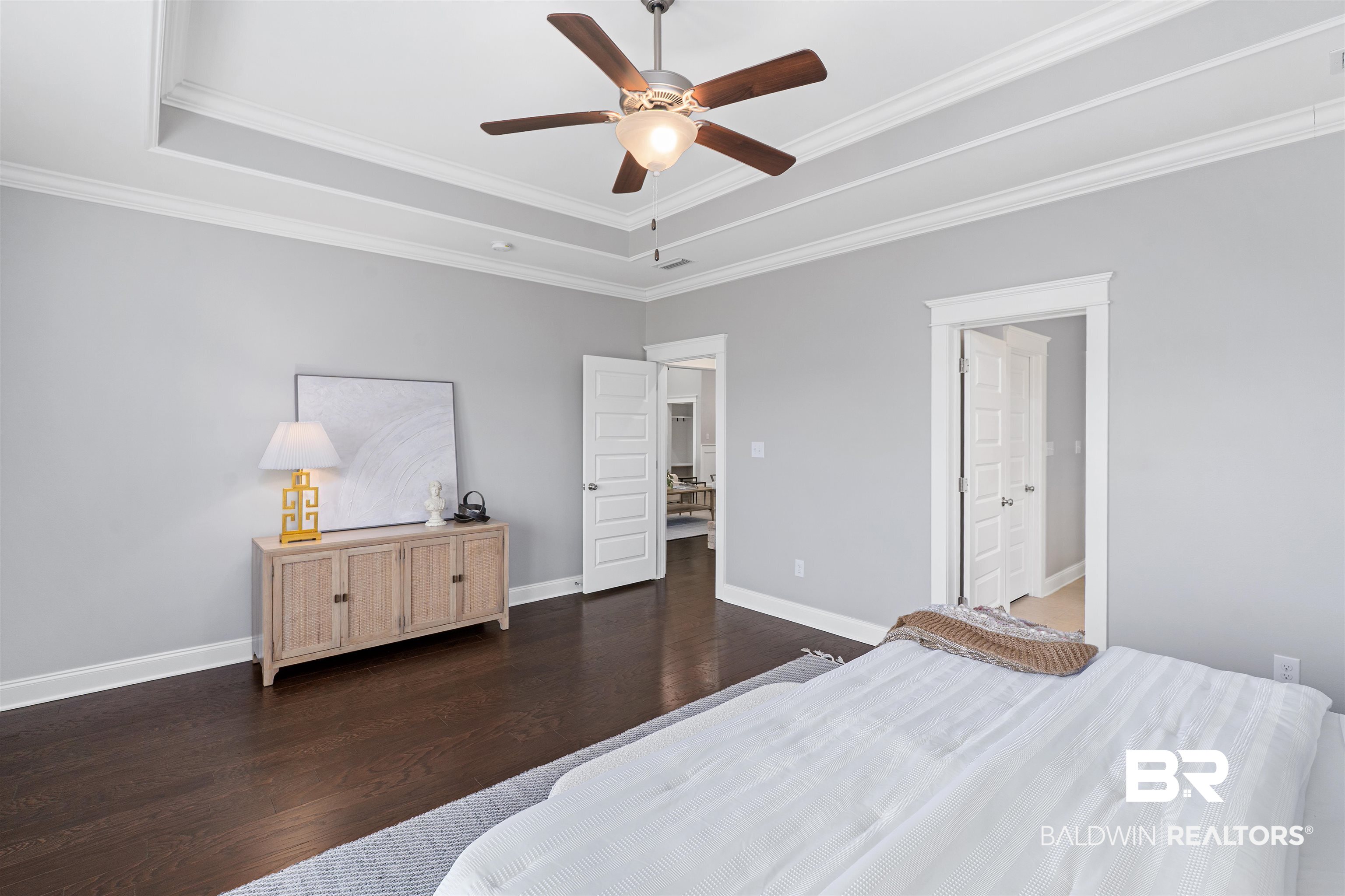 24838 Slater Mill Road Daphne, AL 36526 - Photo 33 of 46 Bedroom featuring dark wood-type flooring, a tray ceiling, ceiling fan, and ornamental molding