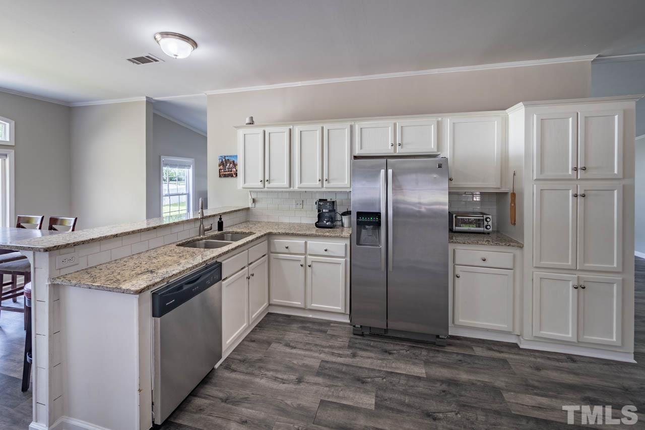 10150 Chambers Road Raleigh, NC 27603 - Photo 8 of 29 a kitchen with a refrigerator sink and cabinets
