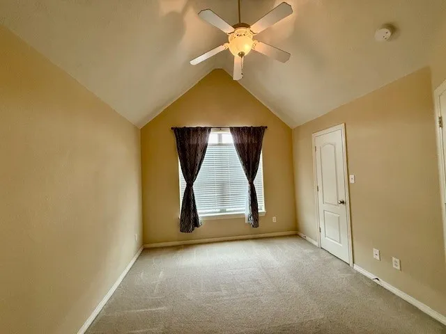 an empty room with a ceiling fan and a window