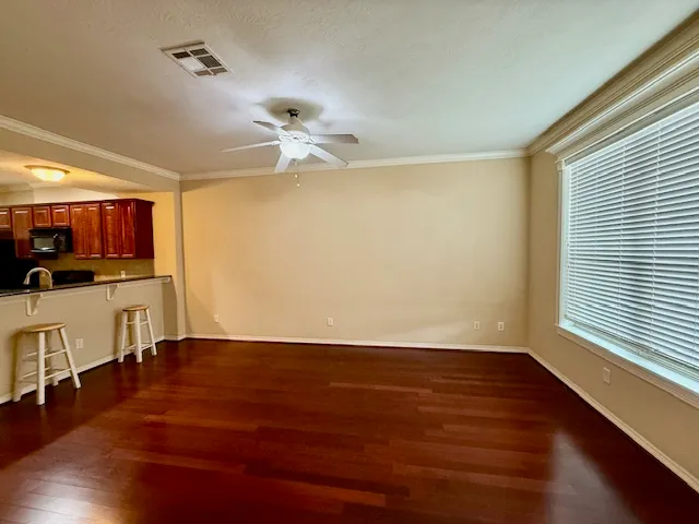 a view of a room with wooden floor and ceiling fan