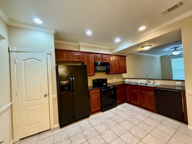 a kitchen with stainless steel appliances granite countertop a refrigerator and a sink