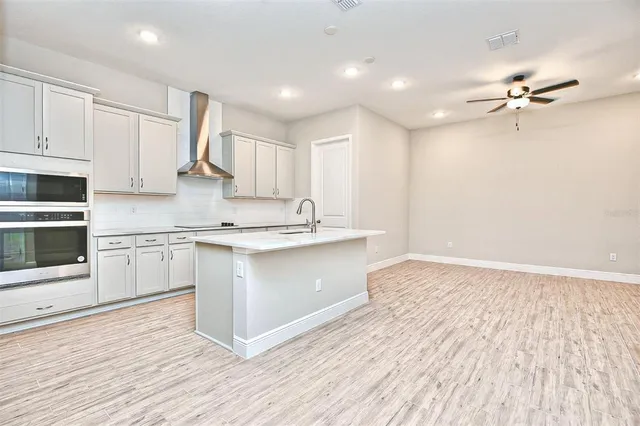 a kitchen with kitchen island white cabinets and stainless steel appliances