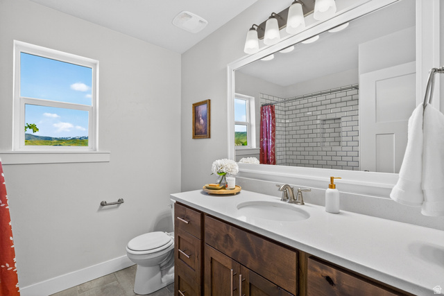 681 Island Road Morgan, UT 84050 - Photo 18 of 49 Bathroom featuring a single window, a dark wood-finish vanity with a light countertop, a built-in sink, and a large mirror with overhead lighting