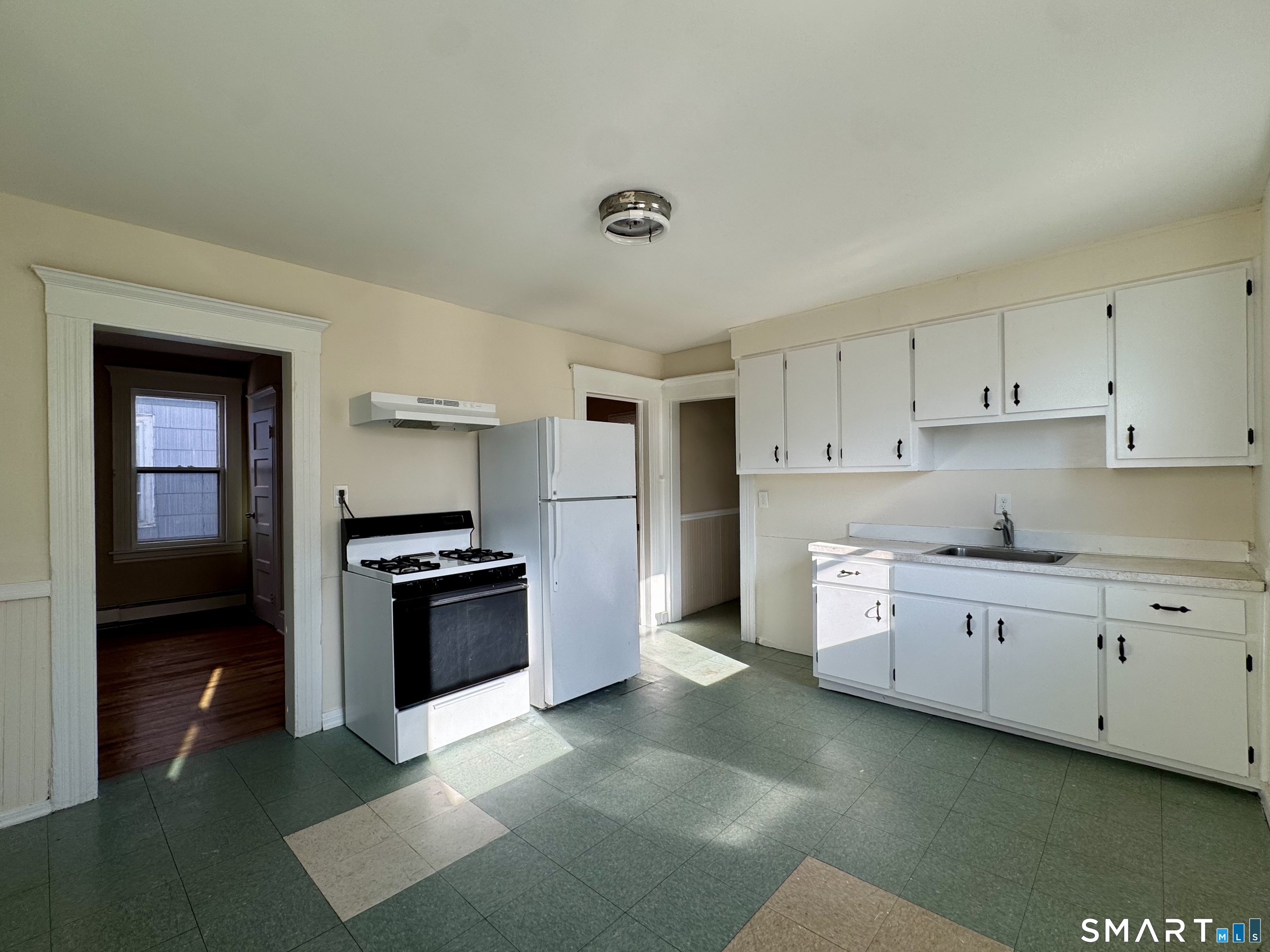 182 Sheridan Street, Unit 2 Bridgeport, CT 06610 - Photo 3 of 9 a kitchen with granite countertop white cabinets and stainless steel appliances