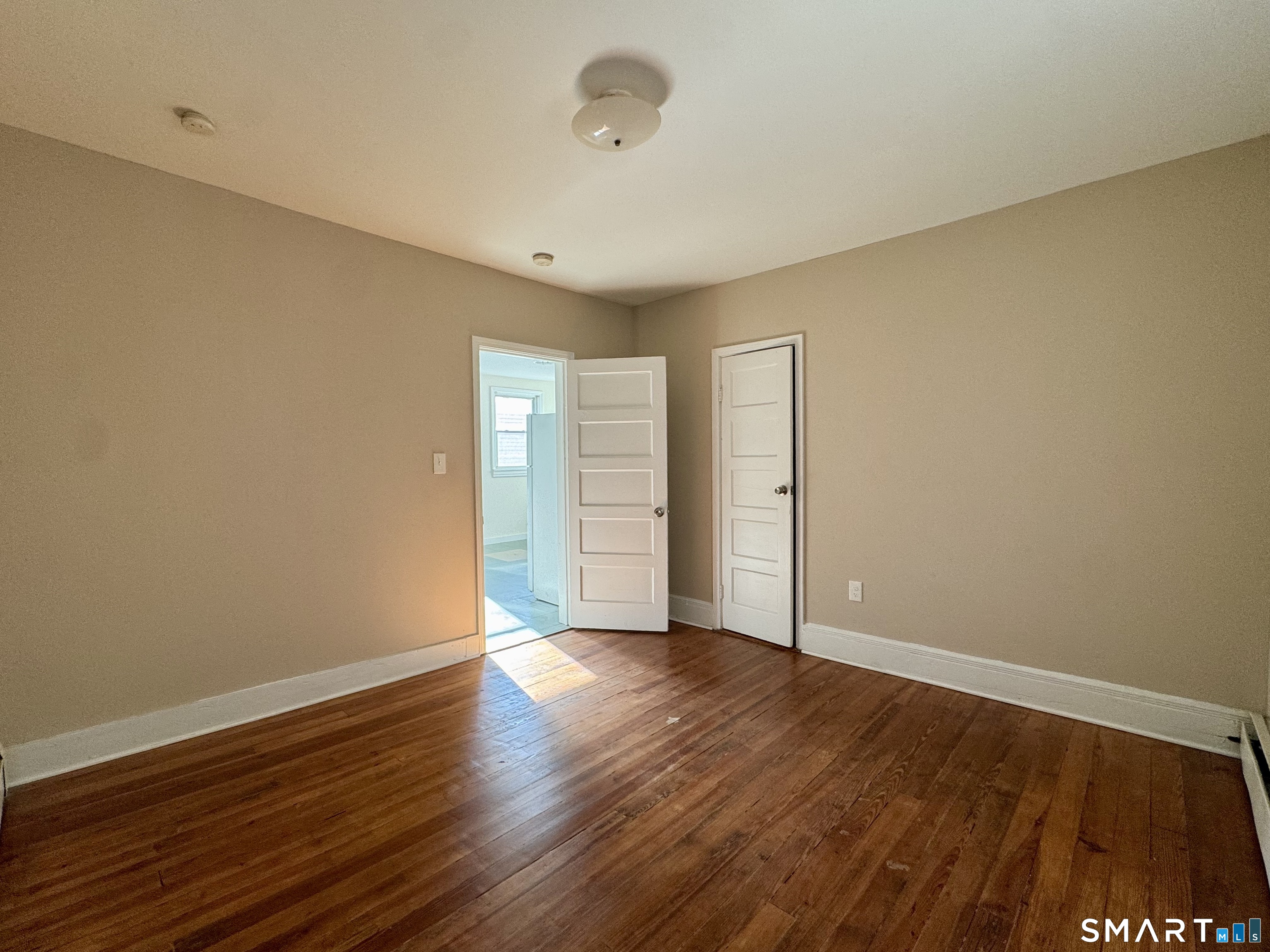 182 Sheridan Street, Unit 2 Bridgeport, CT 06610 - Photo 6 of 9 a view of an empty room with wooden floor