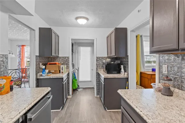 a kitchen with stainless steel appliances granite countertop a refrigerator a stove top oven a sink and dishwasher