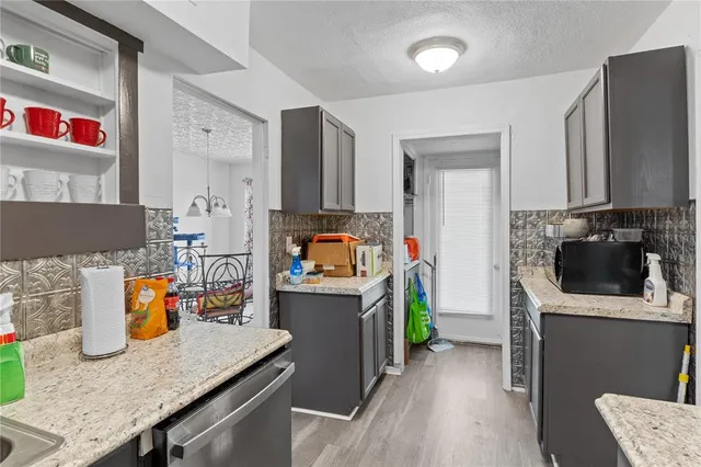 a kitchen with stainless steel appliances granite countertop a refrigerator and a stove top oven