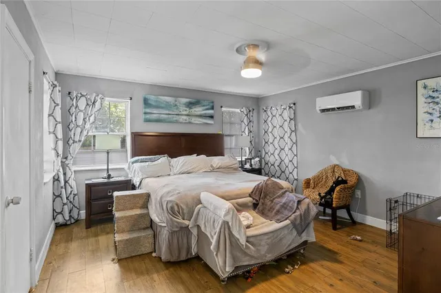 a bedroom with a bed and wooden floor