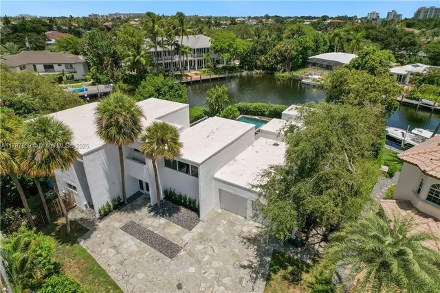 an aerial view of a house with a garden and lake view
