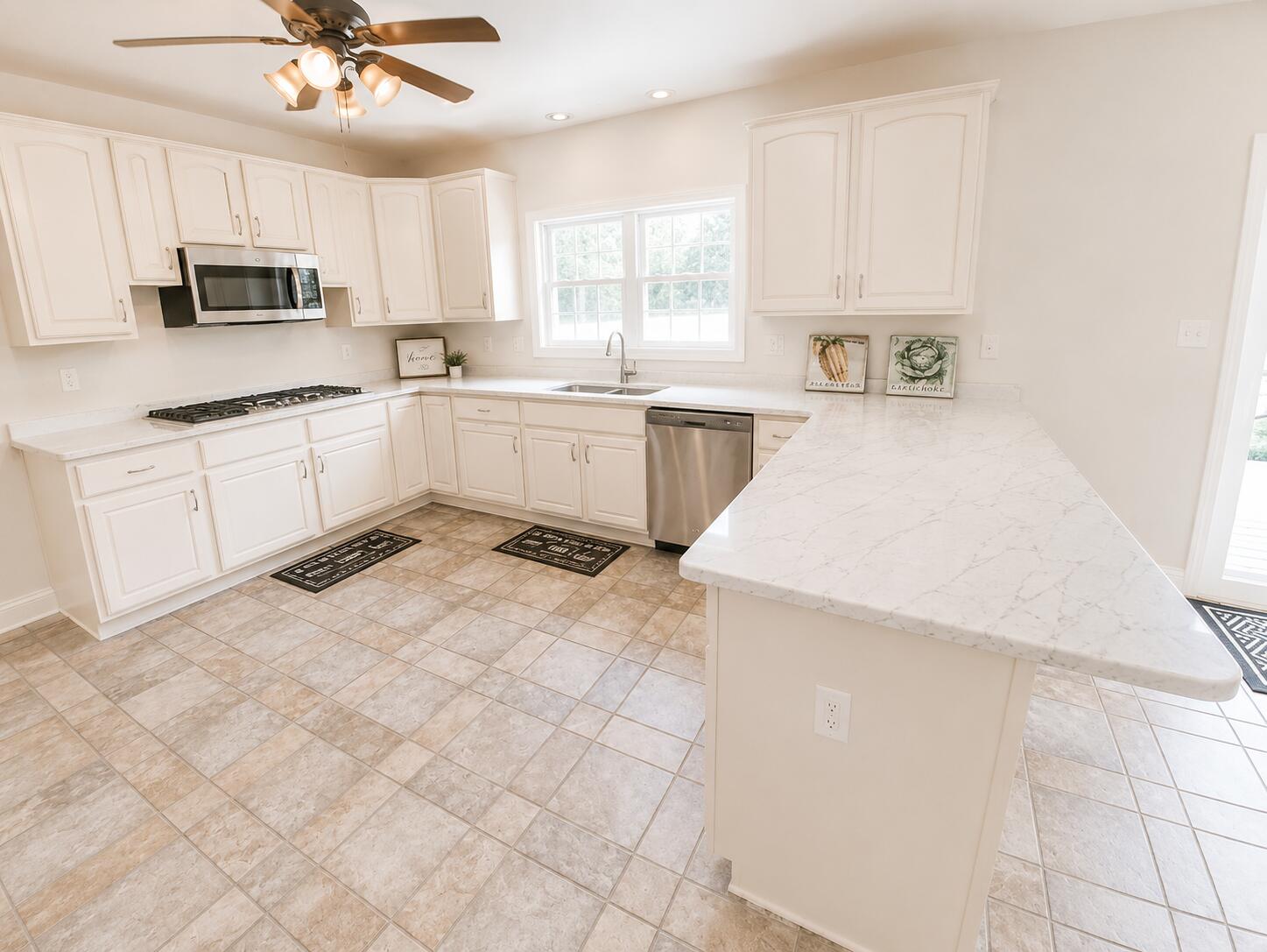 147 Dover Lane Freeport, FL 32439 - Photo 14 of 27 a kitchen with a sink a stove cabinets and a refrigerator