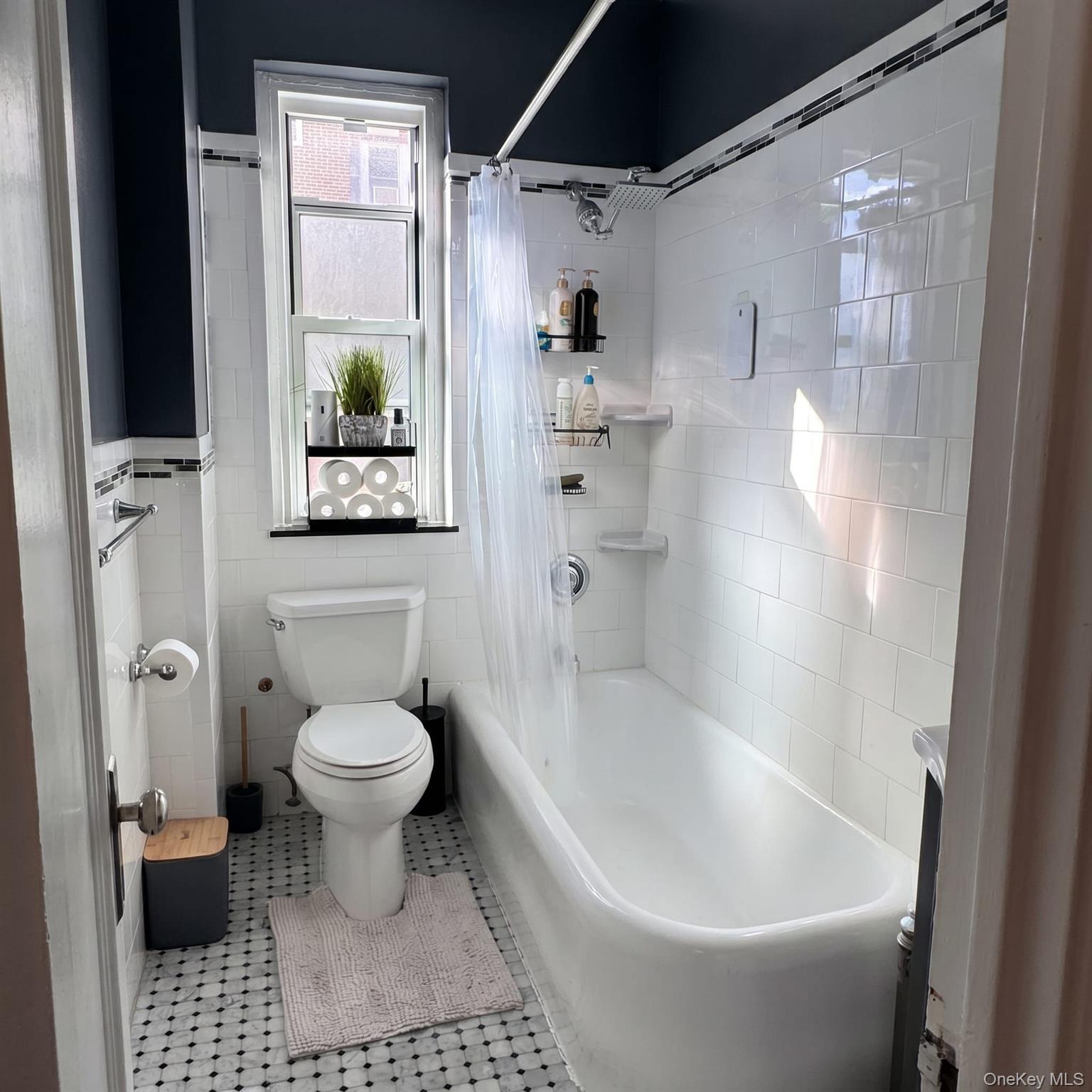 1470 Midland Avenue, Unit 3M Bronxville, NY 10708 - Photo 18 of 20 Bathroom featuring a white subway tile surround, patterned floor tiling, and a window above the toilet