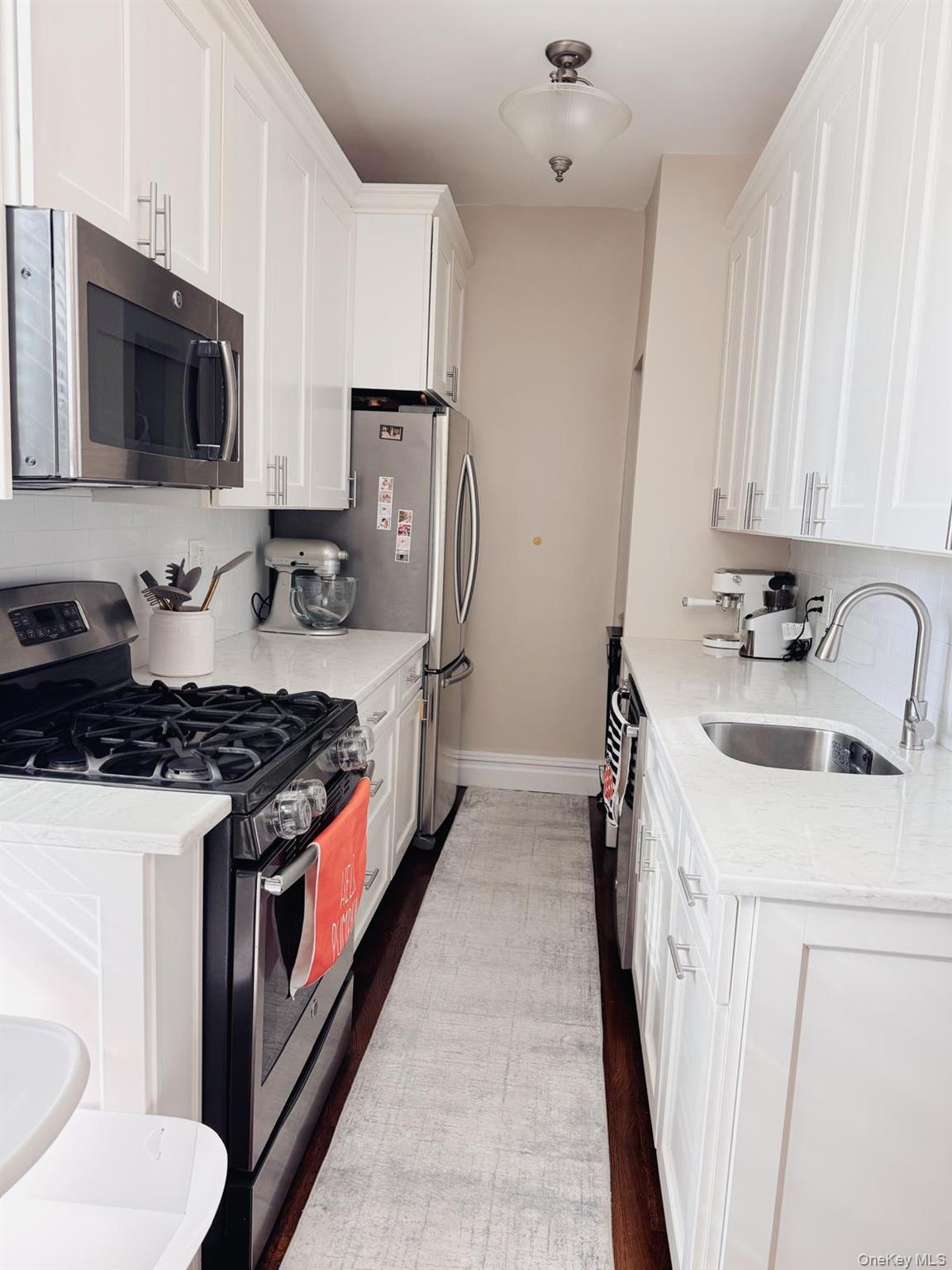 1470 Midland Avenue, Unit 3M Bronxville, NY 10708 - Photo 8 of 20 Galley kitchen featuring white cabinetry, stone countertops, stainless steel appliances, and dark wood-finish flooring