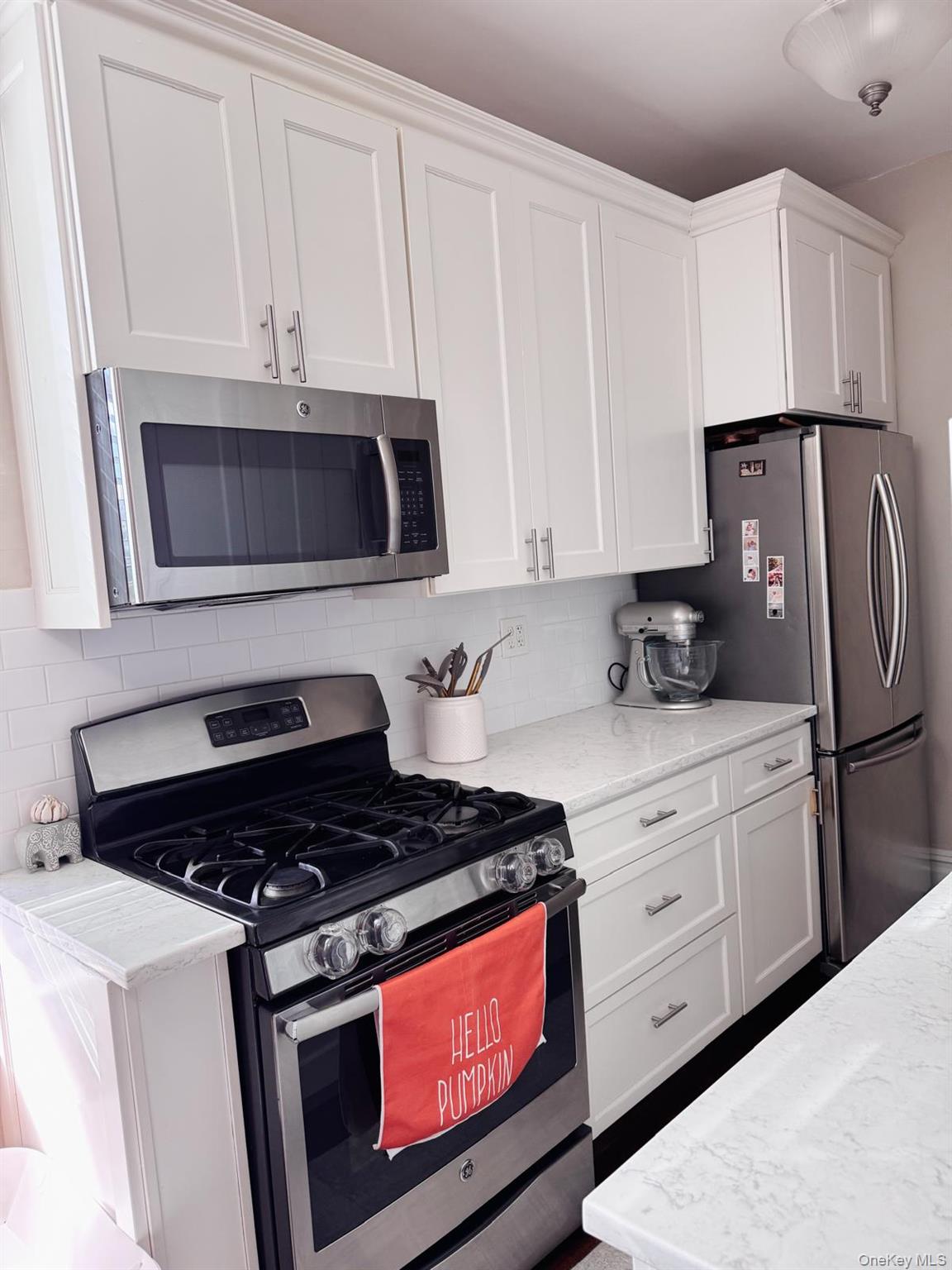 1470 Midland Avenue, Unit 3M Bronxville, NY 10708 - Photo 9 of 20 Kitchen featuring white shaker-style cabinetry, stainless steel appliances, a gas range, white subway tile backsplash, and light-colored countertops