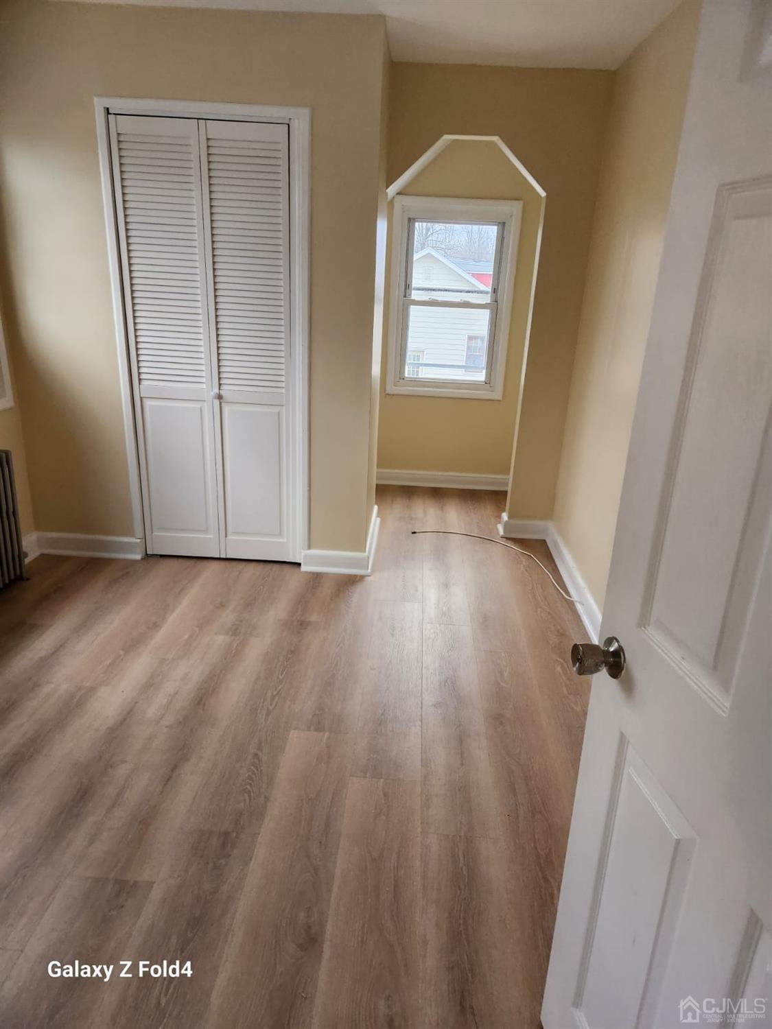 307 2nd Street Middlesex, NJ 08846 - Photo 4 of 8 an empty room with wooden floor and windows