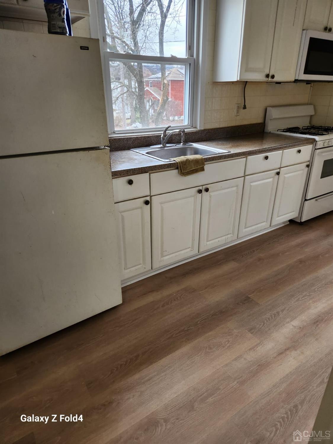 307 2nd Street Middlesex, NJ 08846 - Photo 5 of 8 a kitchen with granite countertop white cabinets and white appliances