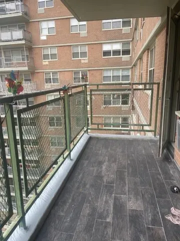 a view of a balcony with a floor to ceiling window and brick wall