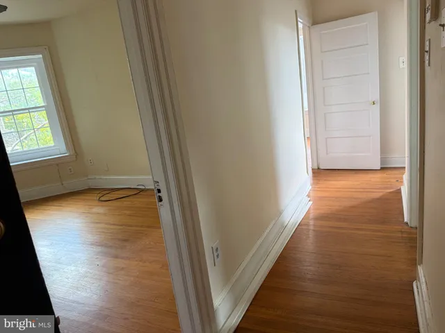 a view of a room with wooden floor and a window