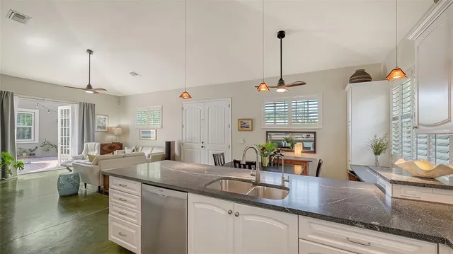 a kitchen with stainless steel appliances granite countertop a sink and a refrigerator