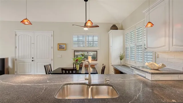 a room with a table chairs wooden floor and a large window