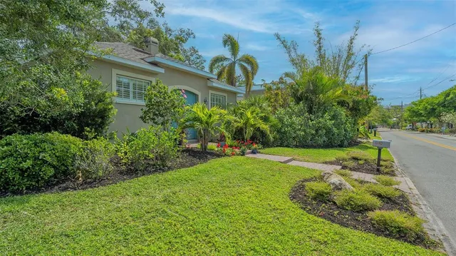 a view of a backyard with plants and a fountain