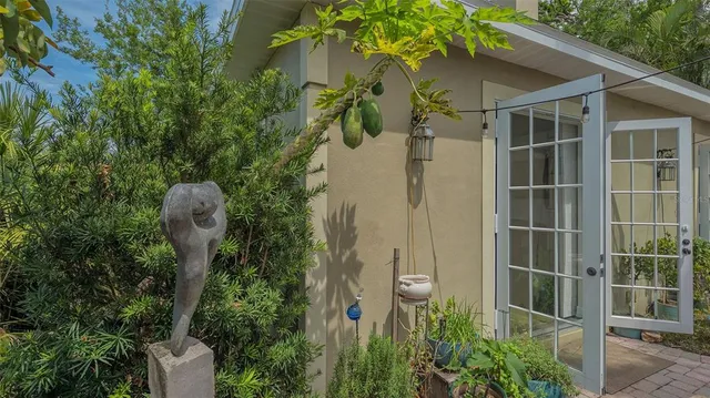 a view of a entryway door with potted plants in front of door