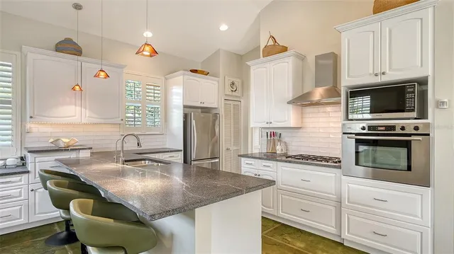 a kitchen with stainless steel appliances granite countertop a refrigerator and a stove